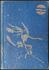 Image of a witch on a broomstick depicted in gilt decoration on a blue cloth book cover